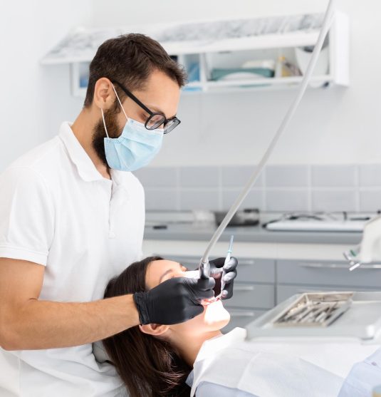 dentist-doctor-in-glasses-filling-teeth-to-female-QGHT5GS.jpg